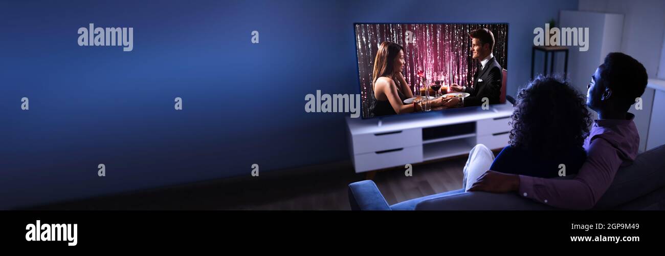 Couple africain regardant un film TV sur écran de télévision en ligne Banque D'Images