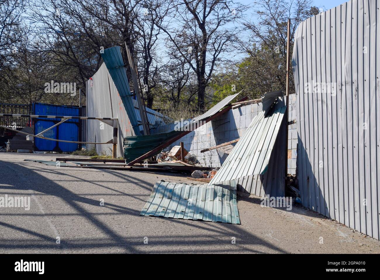 Clôture en ruine faite de métal ondulé. Conséquences de l'ouragan. Banque D'Images