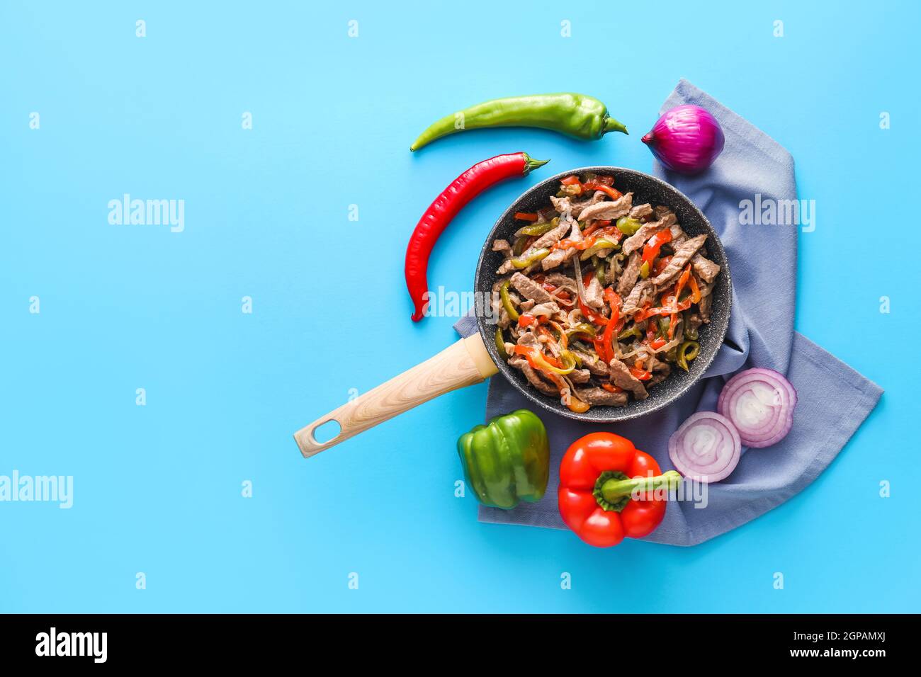 Poêle à frire avec de savoureux fajita et légumes sur fond de couleur Banque D'Images