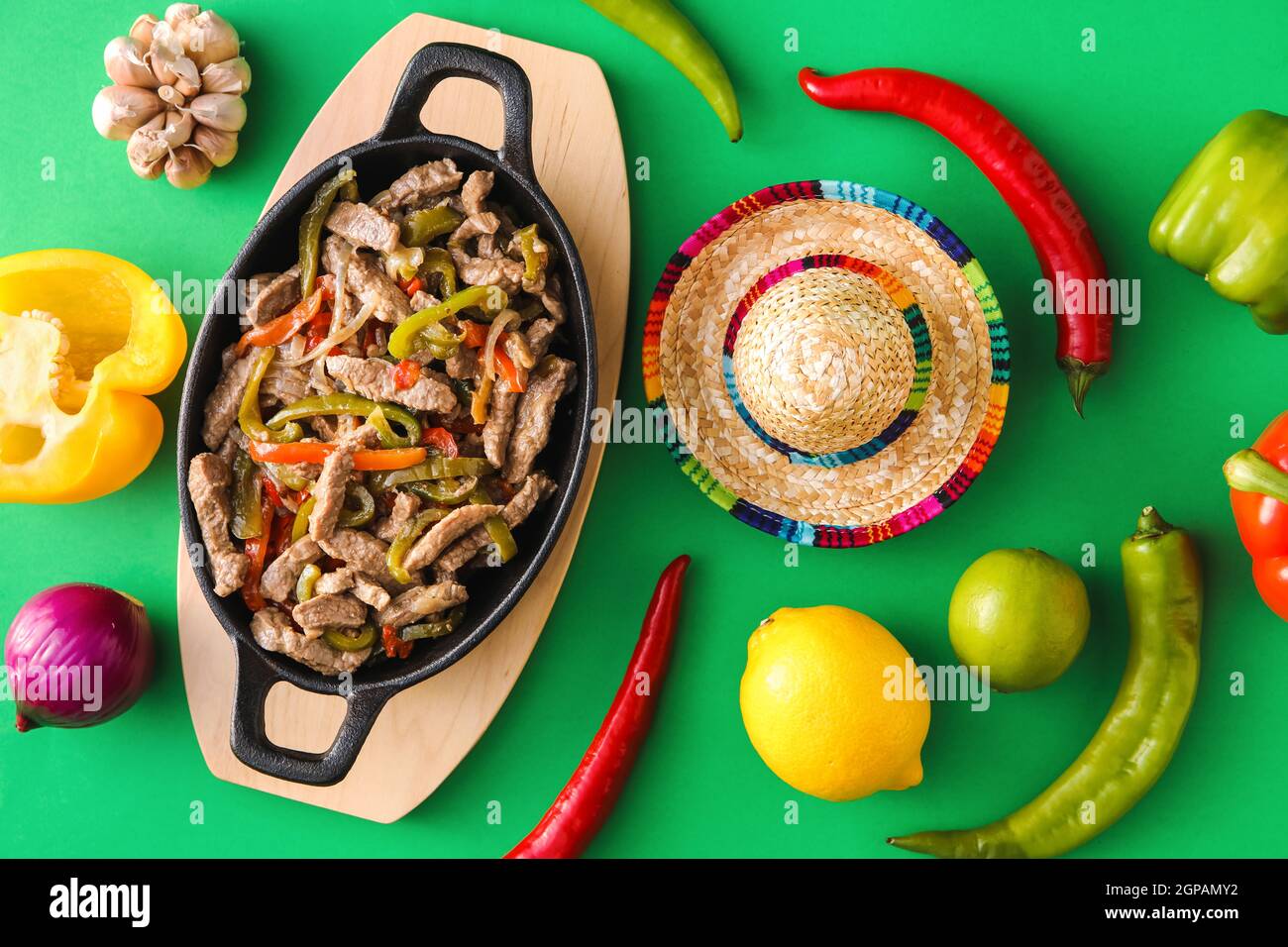 Composition avec de délicieux fajita, légumes et chapeau de sombrero sur fond de couleur Banque D'Images
