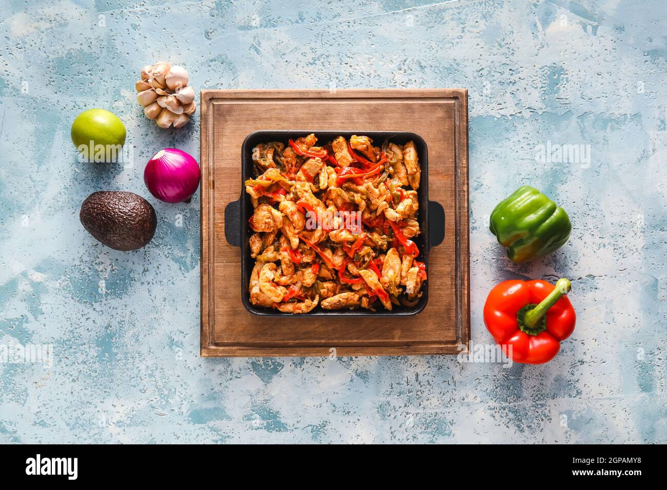 Poêle à frire avec de savoureux poulet Fajita et légumes sur fond de couleur Banque D'Images