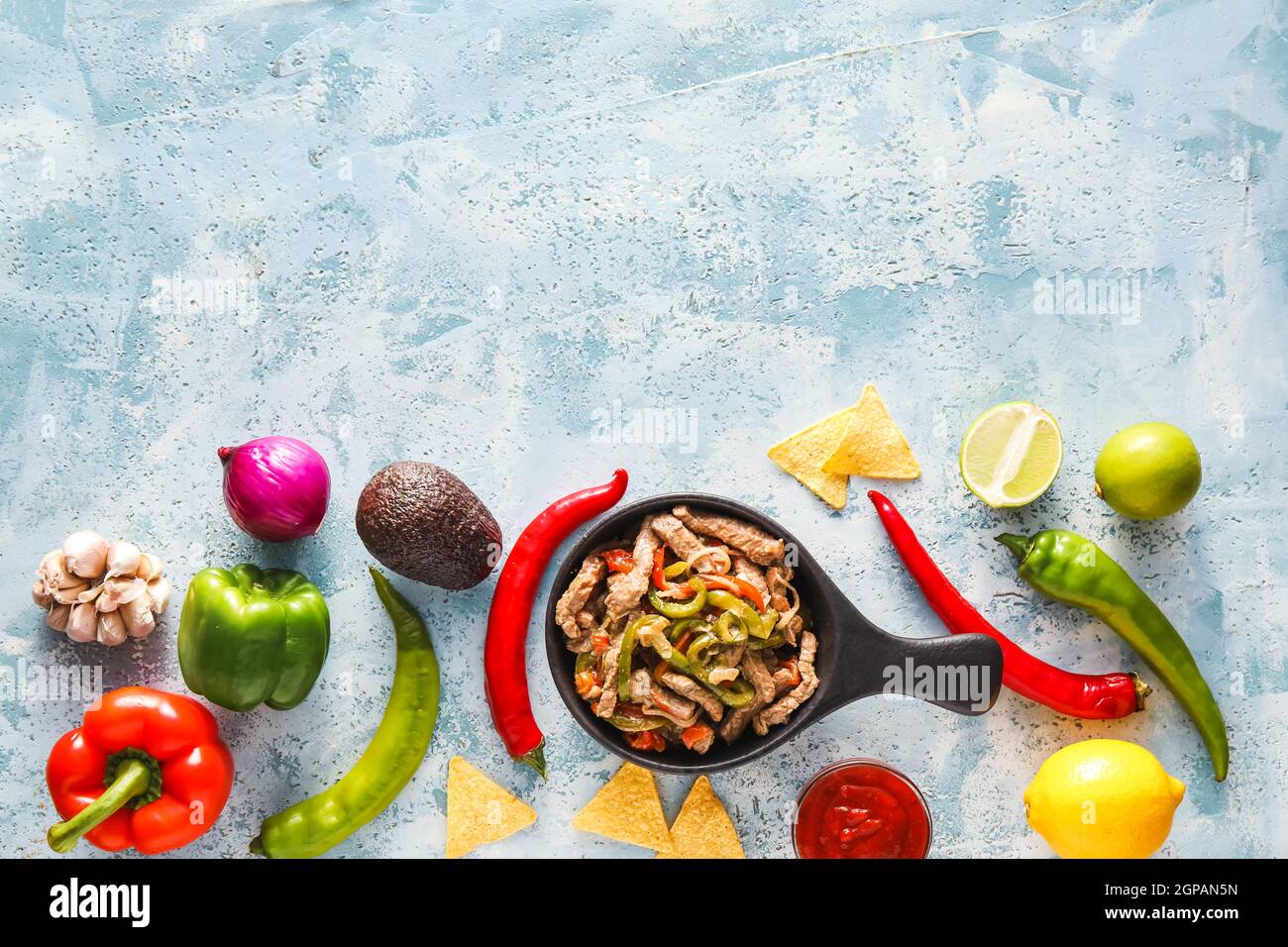 Poêle à frire avec de savoureux bœuf Fajita et légumes sur fond de couleur Banque D'Images