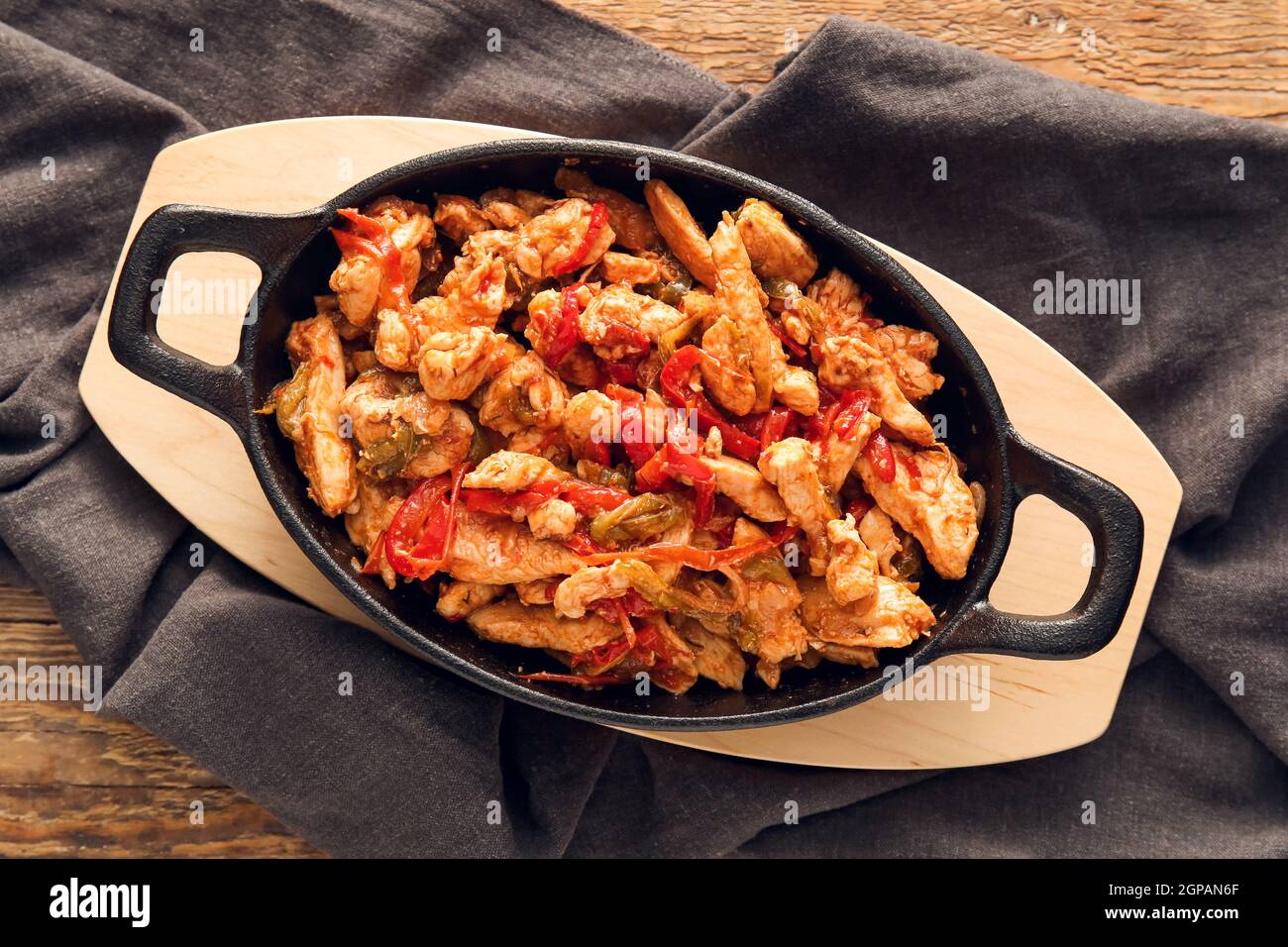 Poêle à frire avec un délicieux poulet Fajita sur fond de bois Banque D'Images