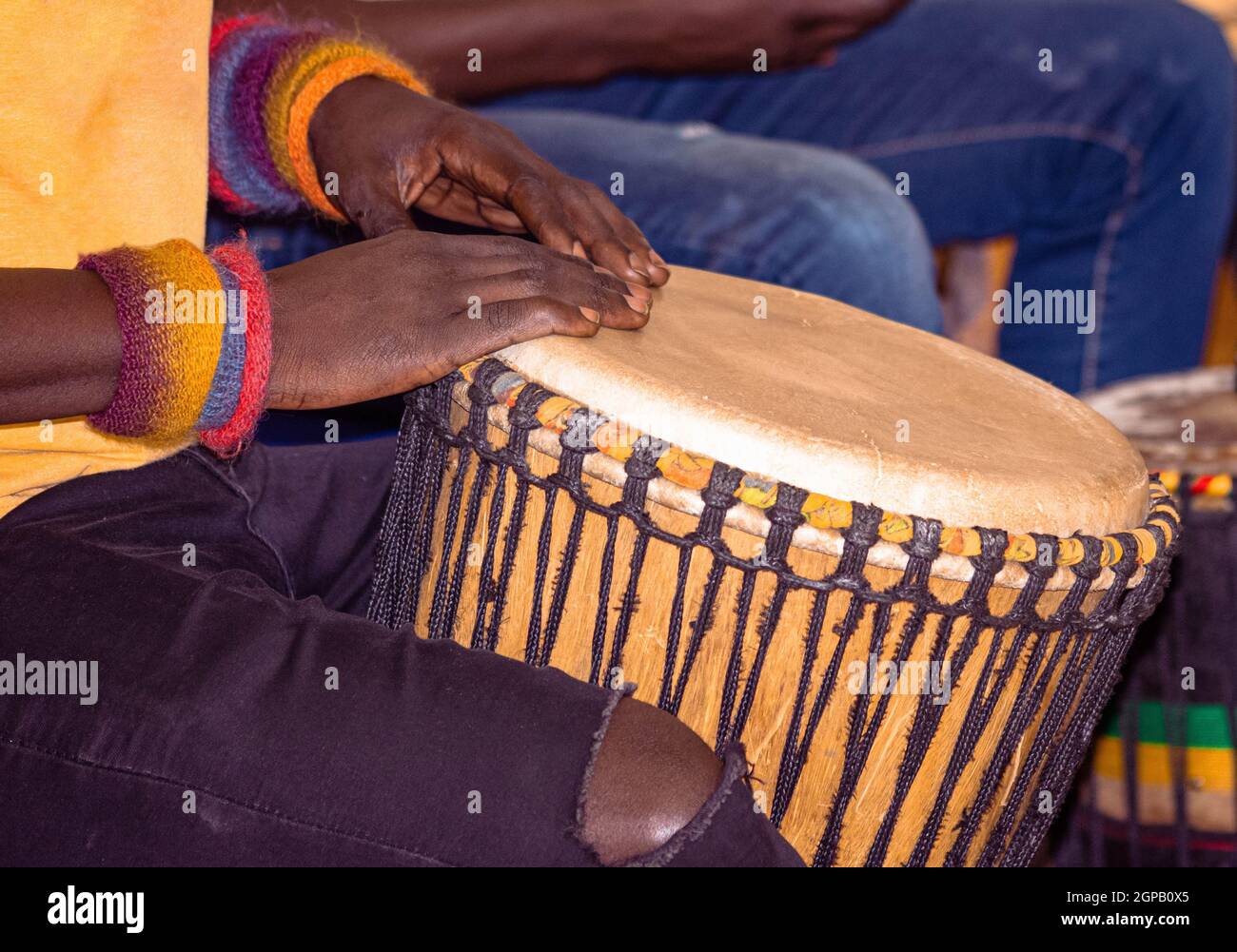 Gros plan d'un batteur africain djembe. Batteur jouant de la musique africaine à percussion. Instruments de musique à percussion ethnique Djembe et mains masculines. Rythme de Banque D'Images