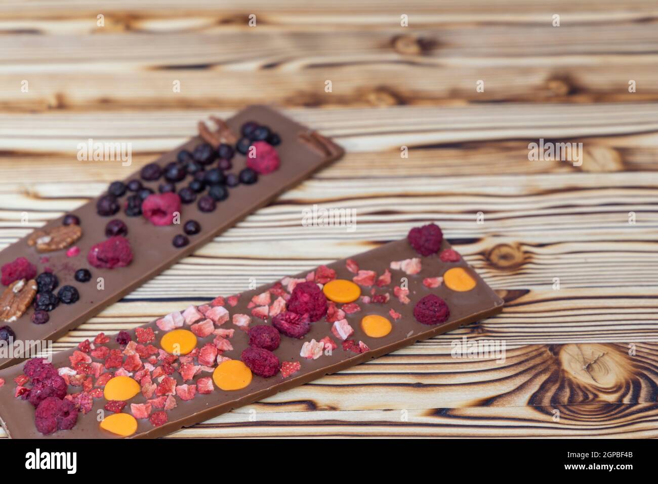 différents types de chocolat avec fruits séchés sur une planche en bois Banque D'Images