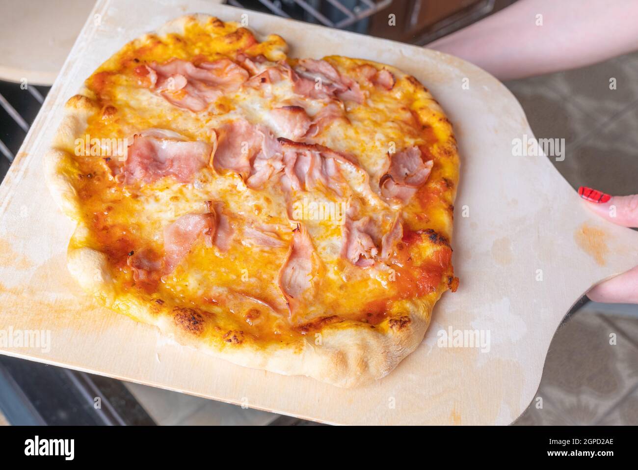 Pizza maison sur une planche à découper en bois, vue rapprochée d'en haut. Banque D'Images