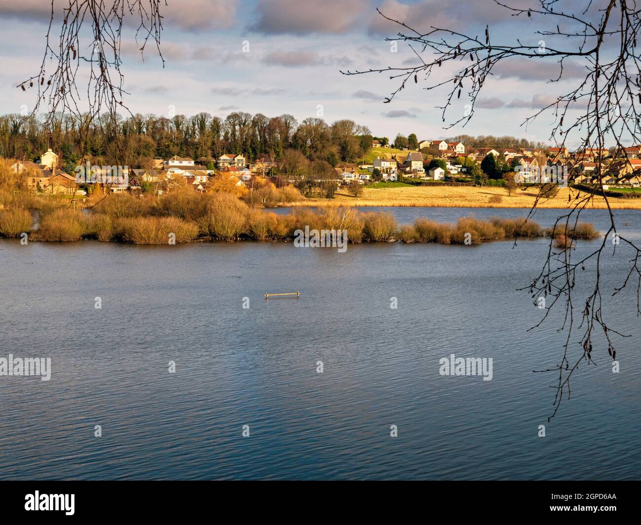 Vue sur un lac dans la réserve naturelle de Fairburn ings, West Yorkshire, Angleterre, jusqu'au village de Fairburn Banque D'Images