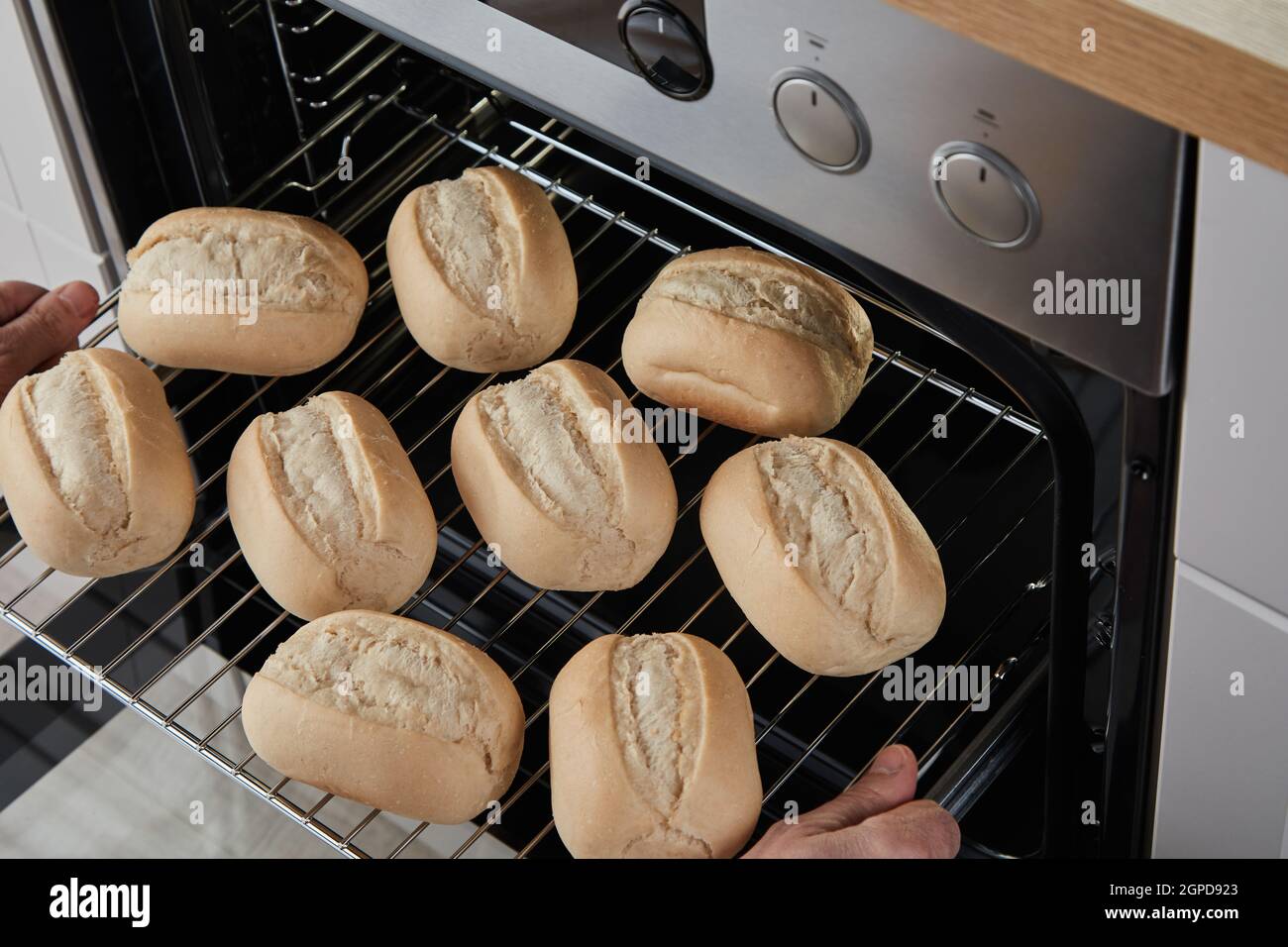 Par dessus la personne anonyme plaçant le rack de glisse avec des petits  pains dans un four à chaleur tournante Photo Stock - Alamy