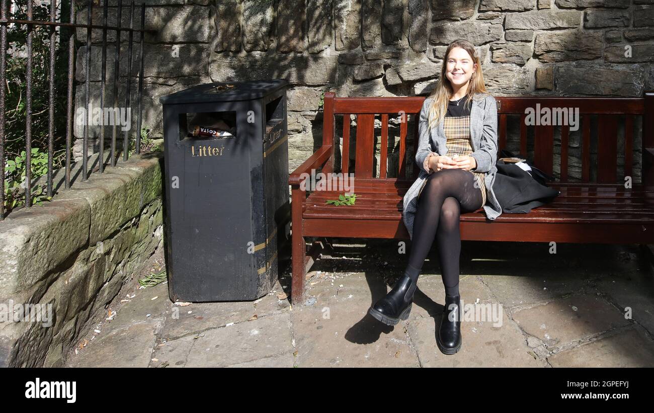 Jeune fille ayant une collation sur le banc Banque D'Images