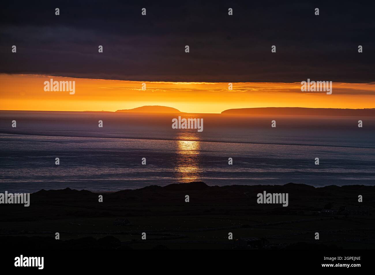 Coucher de soleil entre la péninsule de Llyn et l'île Bardsey à Cardigan Bay. Banque D'Images