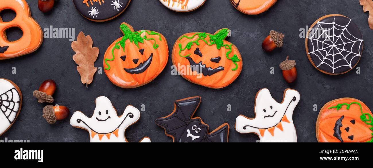 Citrouilles d'Halloween drôles et effrayantes sur fond de pierre sombre. Biscuits maison lumineux pour Halloween partie - image Banque D'Images