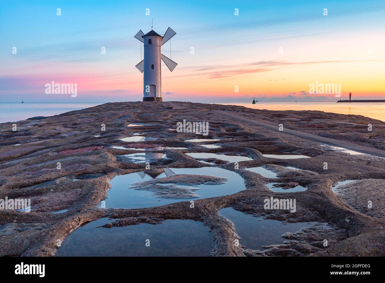 Mer Baltique et Stawa Mlyny, balise de navigation en forme de moulin à vent au coucher du soleil, symbole officiel de Swinoujscie, Pologne Banque D'Images