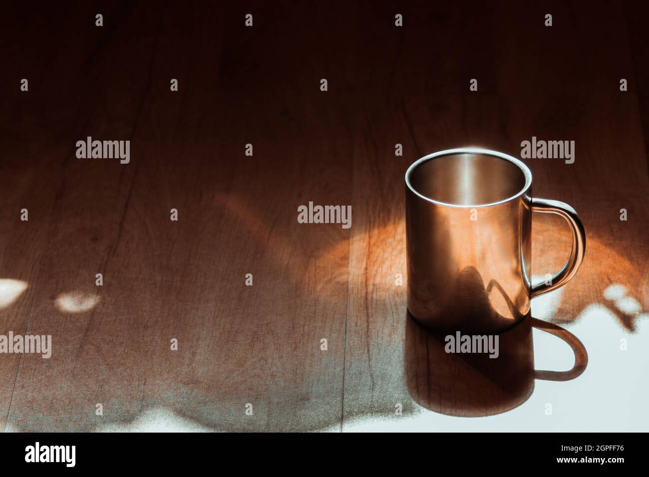 Une tasse en aluminium avec poignée se tient sur un fond en bois. Banque D'Images