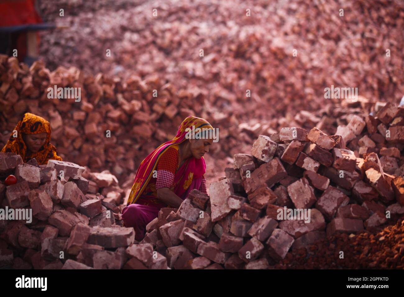 Les femmes bangladaises travaillent dans un chantier de briques à l'intérieur de la rivière Turag, dans la région d'Aminbazar, à Dhaka, le 15 mars 2020. Banque D'Images