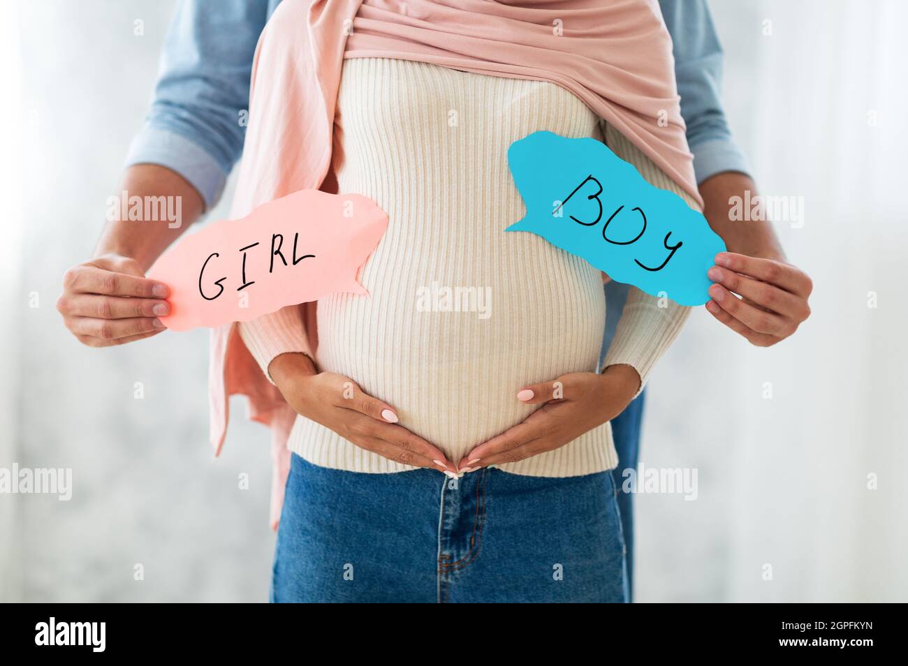 Un Jeune Couple Musulman Tenant Des Cartes De Garcon Et De Fille Pres Du Ventre De La Grossesse Devinant Le Sexe De Leur Futur Bebe Photo Stock Alamy