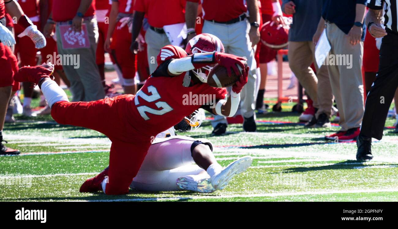 Un ballon de football d'école secondaire se renfond dans la zone finale pour un toucher de balle pendant un match. Banque D'Images