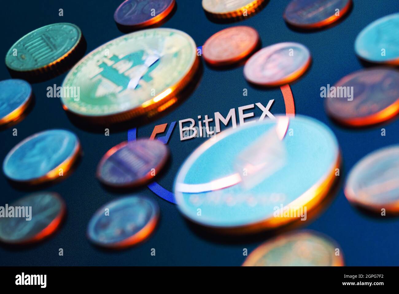 BitMEX est une plate-forme d'échange de crypto-monnaies et de négociation de produits dérivés. Logo BitMEX entouré de pièces de monnaie floues. Banque D'Images