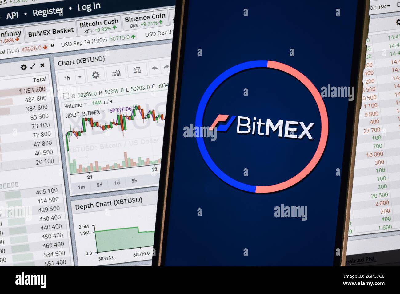 Un smartphone avec le logo BitMEX sur l'arrière-plan de la page Web de trading en direct. Banque D'Images