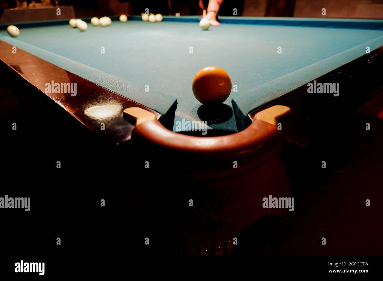 le joueur de billard prévoit de marquer une boule de billard dans la poche d'angle de la table de billard. Banque D'Images