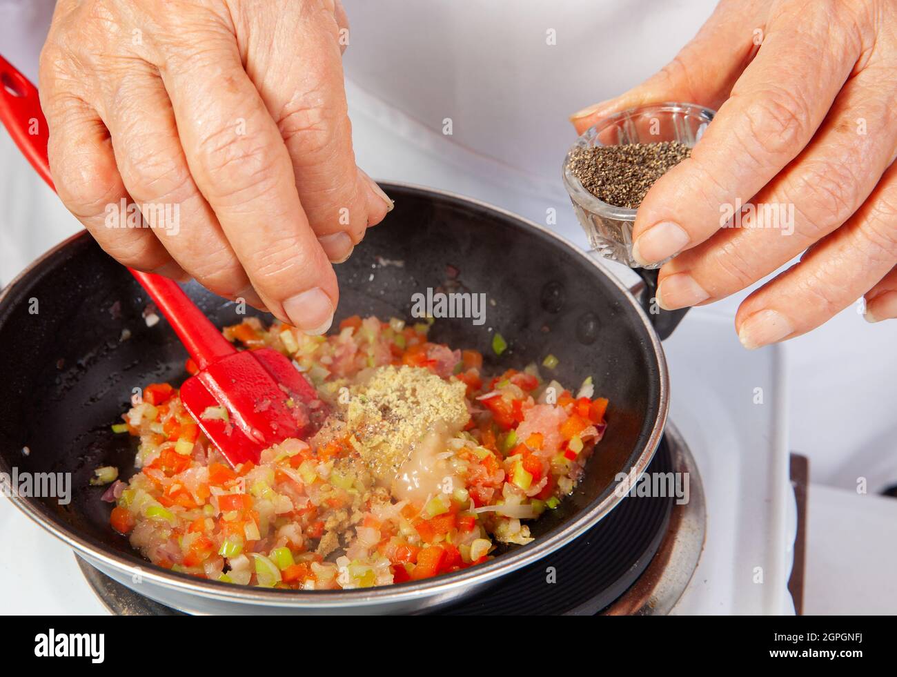 Préparation de la sauce traditionnelle colombienne hogao ou criollo (salsa criolla) à base d'oignons, de tomates, de poivrons et de coriandre Banque D'Images