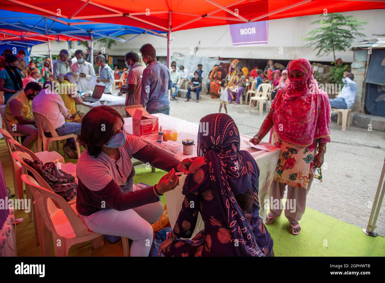 Un travailleur de la santé a vu injecter de la covaxine à une femme bénéficiaire lors de la campagne spéciale de vaccination gratuite pour les habitants de taudis par le gouvernement de Delhi à Vijay Ghat Yamuna Pushta.New Delhi, 876,663,490 doses totales de vaccination admises jusqu'au 29 septembre, La campagne nationale de vaccination a été lancée le 16 janvier et les travailleurs de la santé ont été inoculés dans la première phase. La vaccination des travailleurs de première ligne a commencé à partir du 2 février. La phase suivante de la vaccination contre Covid-19 a commencé à partir du 1er mars chez les personnes de plus de 60 ans et chez les personnes de 45 ans et plus atteintes d'une condition de co-morbide spécifiée Banque D'Images