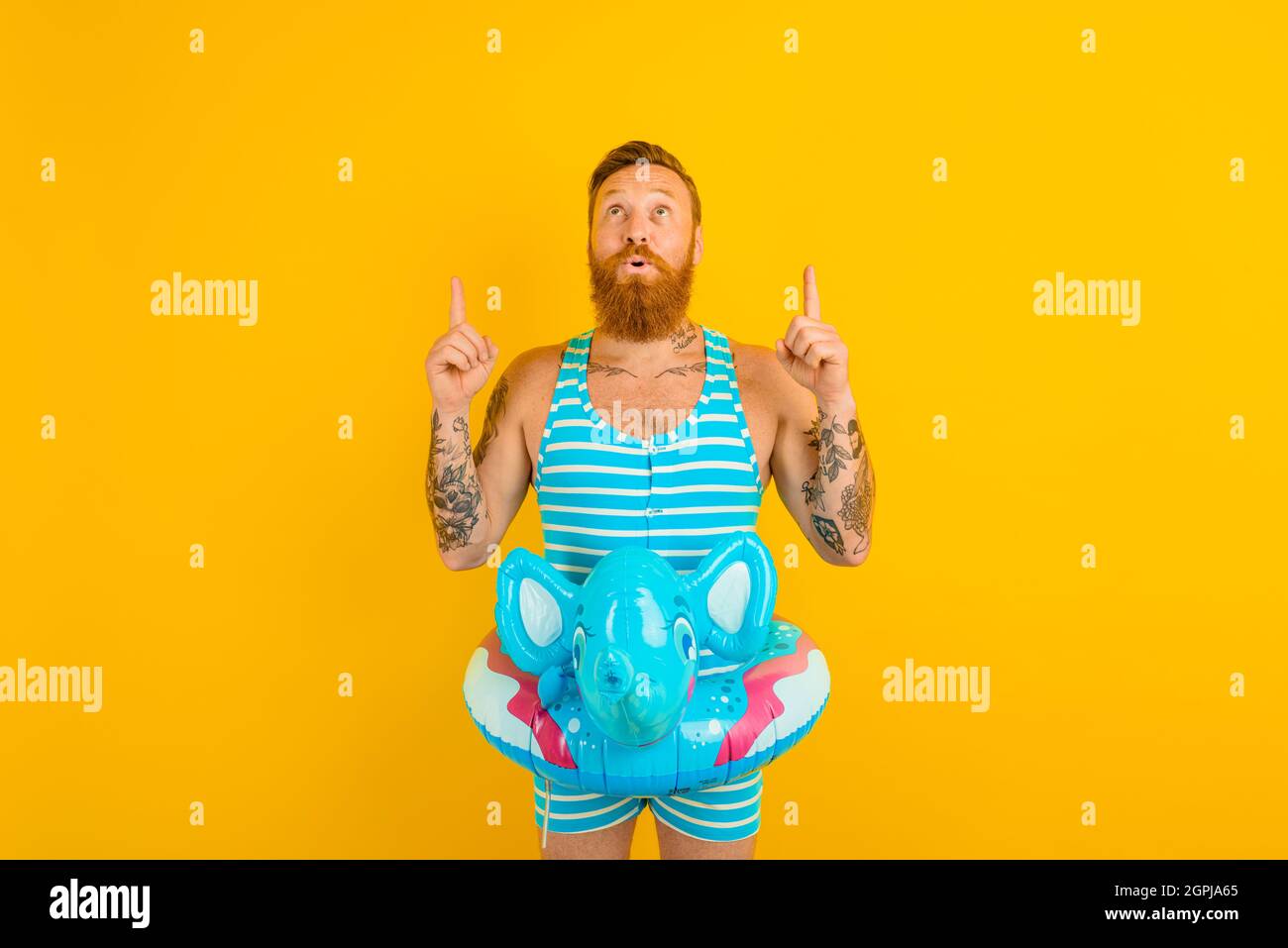 homme avec donut gonflable avec éléphant est prêt à nager Banque D'Images