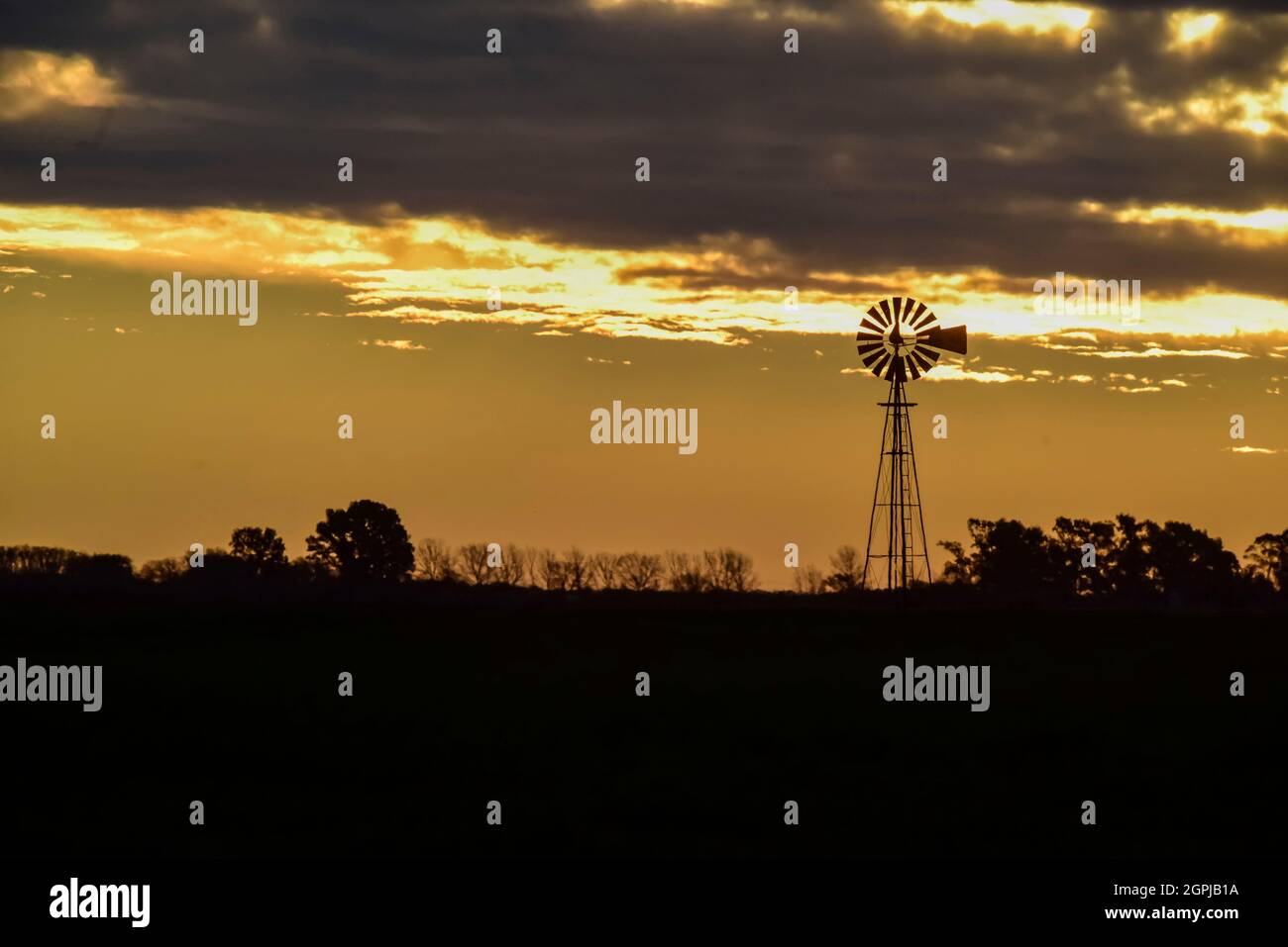 Moulin au coucher du soleil dans la campagne Argentine, province de Pampas, Patagonie, Argentine. Banque D'Images