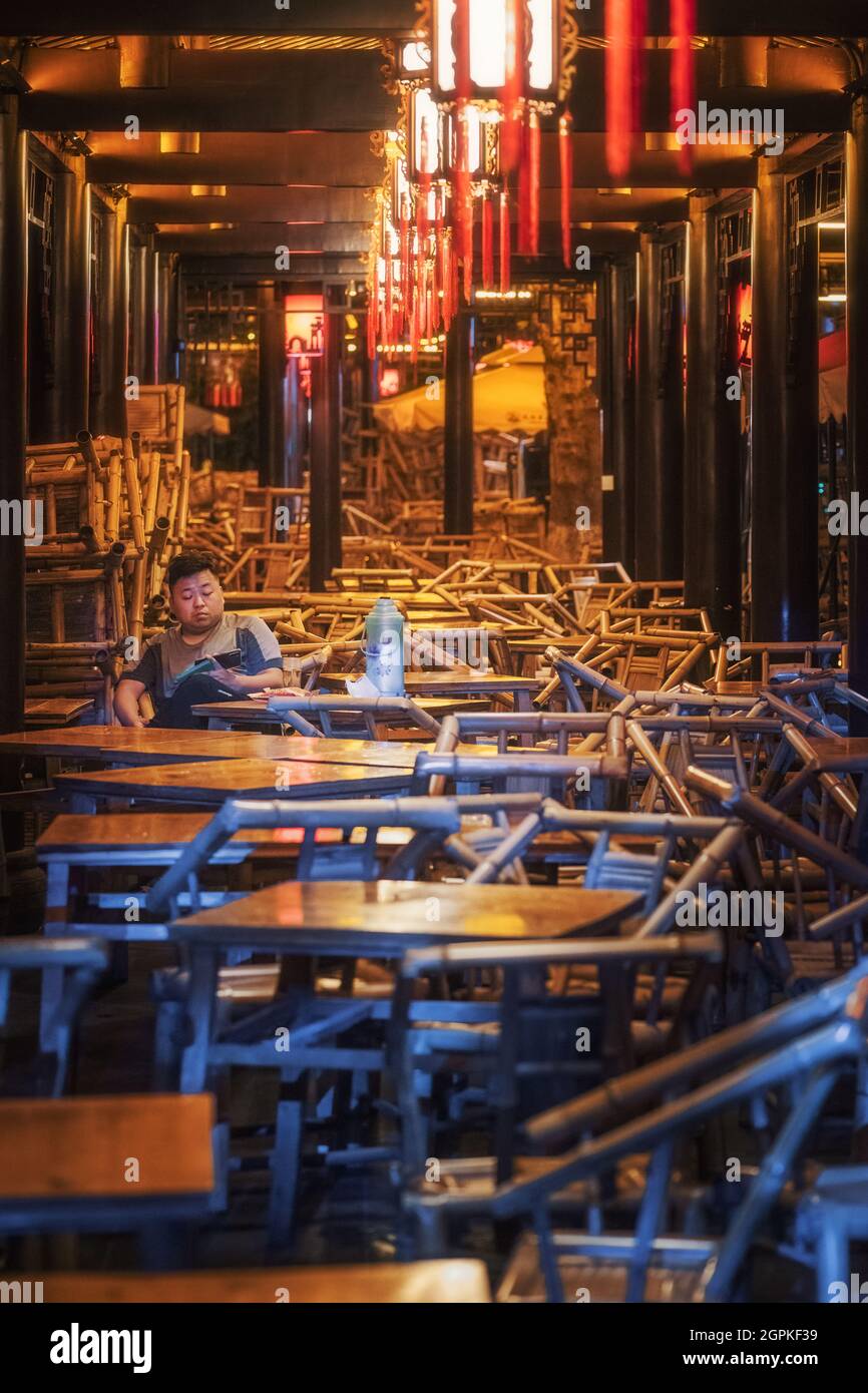 Chengdu, province du Sichuan, Chine - 1 septembre 2021 : un homme qui a le thé dans l'ancien salon de thé Heming illuminé la nuit dans le parc des gens Banque D'Images