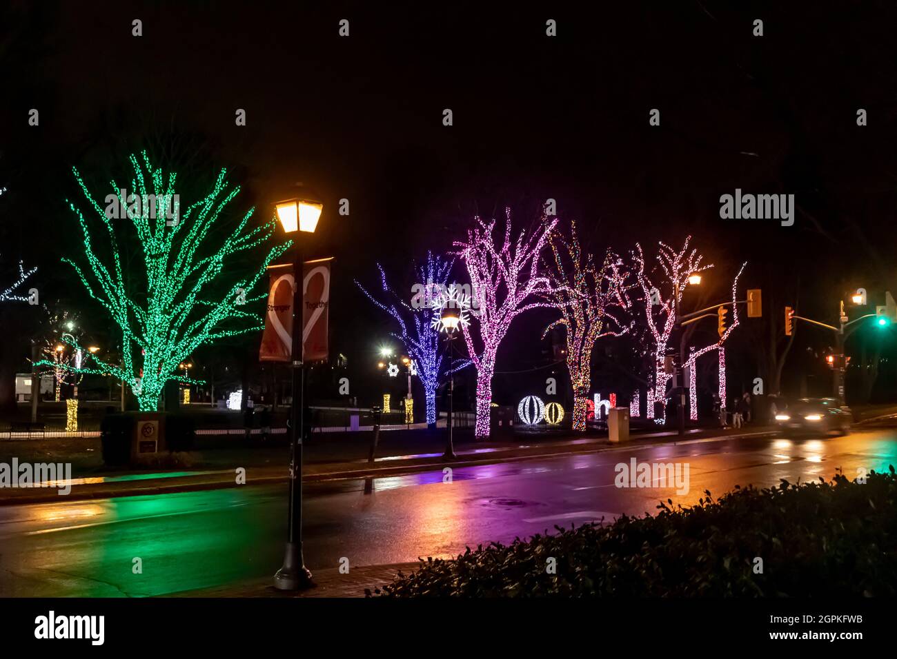 Rues humides reflétant les couleurs vives des lumières de fête Banque D'Images