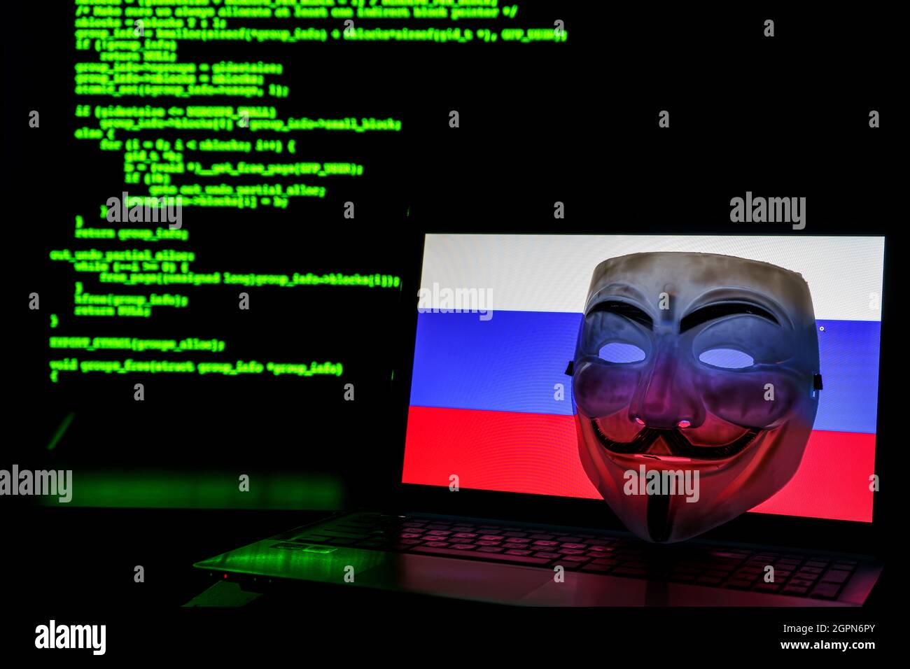 Pirates anonymes russes avec masque vendetta. Drapeau russe et code de programmation en arrière-plan Banque D'Images
