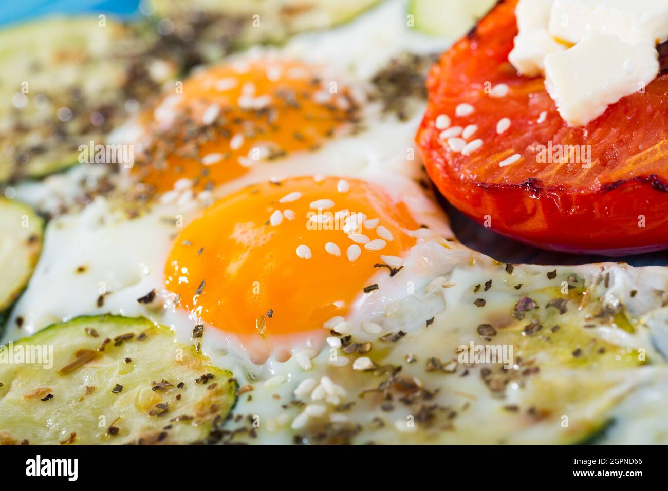 Délicieux petit déjeuner composé d'œufs frits avec des courgettes cuites au four, des tomates et du fromage doux. Banque D'Images