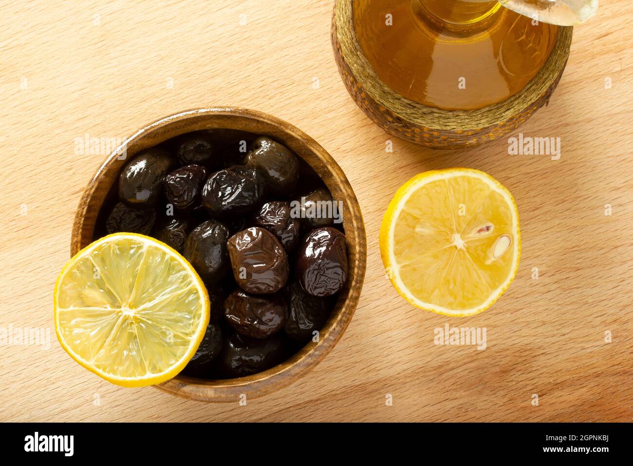 Une assiette d'olives et une tranche de citron. Huile d'olive biologique. Banque D'Images