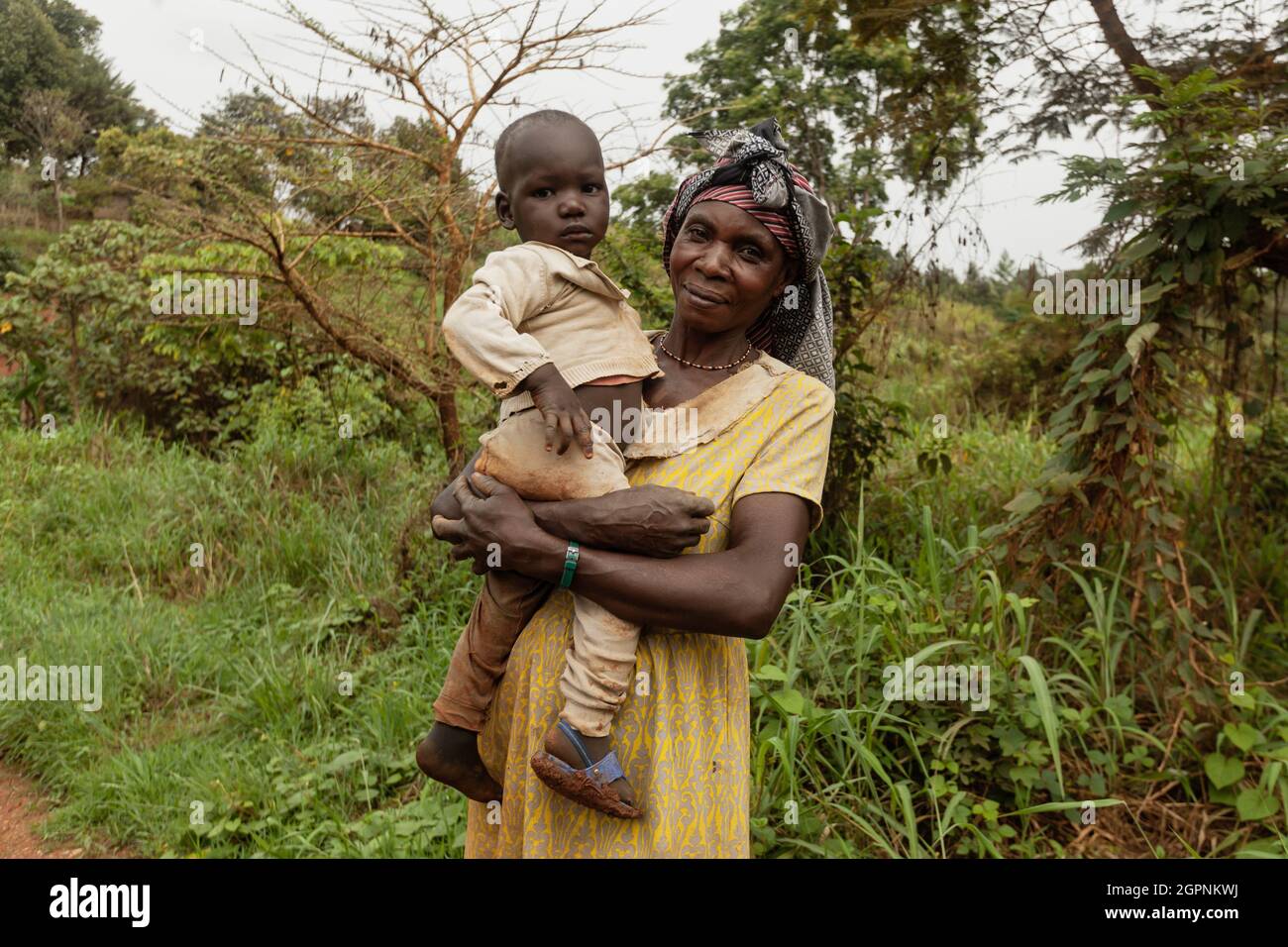 PARC NATIONAL DE KIBALE, OUGANDA - 15 MARS 2018 : une femme non identifiée tient son petit enfant dans ses bras Banque D'Images