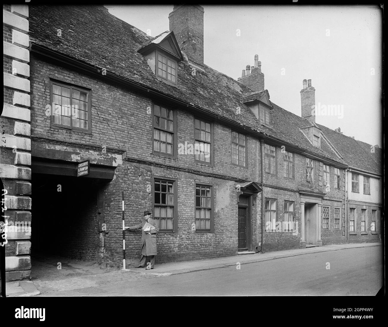 Burnham House, 11-13, rue Nelson, Kings Lynn, King's Lynn et West Norfolk, Norfolk, 1942. Un homme tenant un poteau de grande envergure à côté de l'entrée de la calèche de Burnham House au 11-13, rue Nelson. Banque D'Images