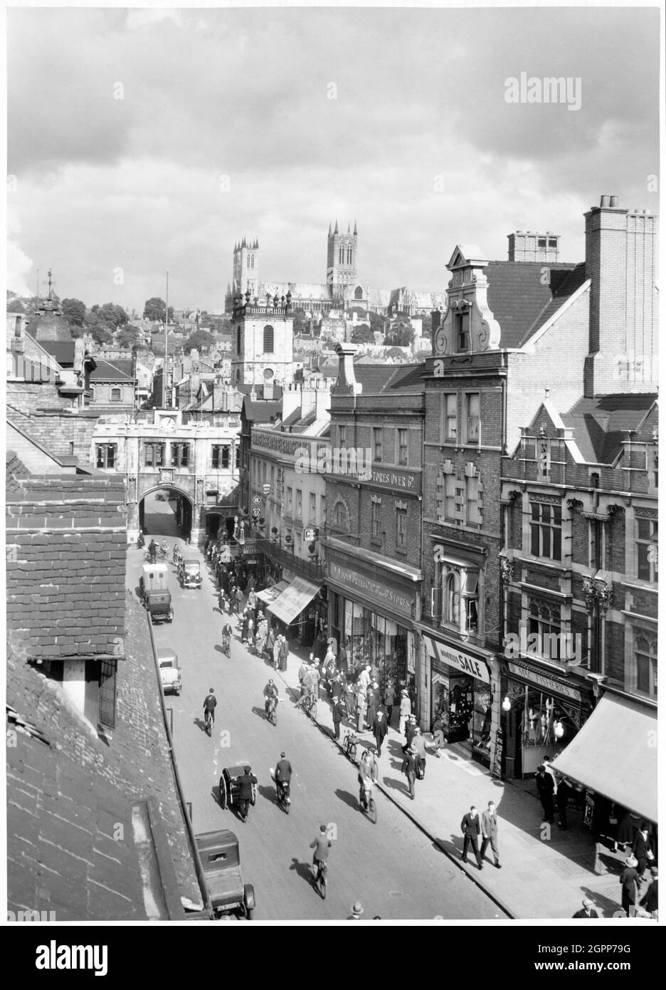 High Street, Lincoln, Lincolnshire, début des années 1930. Une vue en hauteur depuis High Bridge qui donne sur High Street en direction de Stonbow avec la tour de l'église St Peter at Arches au-delà et la cathédrale de Lincoln au loin. L'église Saint-Pierre d'Arches a été démolie au début des années 1930. Norwich Union House occupe maintenant le site. Banque D'Images