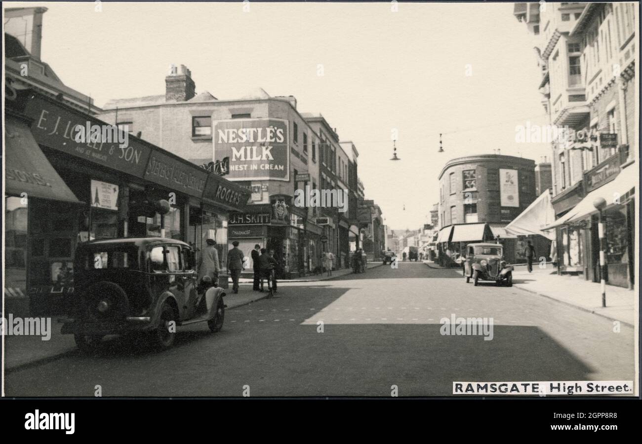 High Street, Ramsgate, Thanet, Kent, c1945-c1965. Une vue sur la rue High Street, vue nord-ouest avec des magasins de chaque côté et non 113 en arrière-plan sur une jonction avec Chatham StreetThe shop en premier plan sur la droite ont des deuxième étages à pans de bois avec des gables et des fenêtres à jets. En face se trouve un magasin nommé E.J. Charmant & amp; son' et un grand panneau pour « Nestlé's Milk » sur un bâtiment plus haut avec une baie d'angle en forme de cage. N0. le modèle 113 est doté d'un avant incurvé et de glaces de pare-soleil alternées Banque D'Images