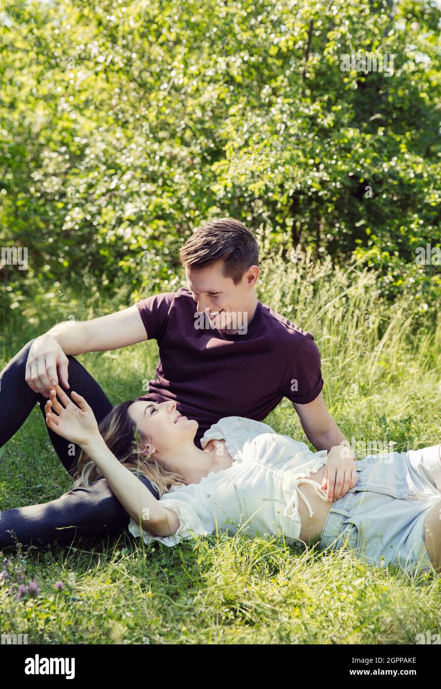 Autriche, Vienne, jeune couple souriant flirtant dans le parc Banque D'Images