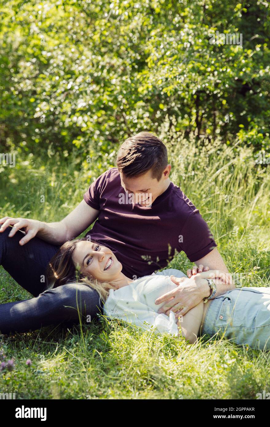 Autriche, Vienne, jeune couple souriant flirtant dans le parc Banque D'Images