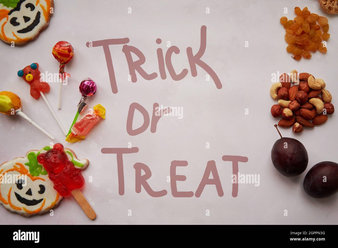 Lettrage de concept Trick or Treat. Aliments sains et malsains en comparaison: Alternative aux bonbons et aux bonbons - noix, fruits et fruits secs. Copier l'espace. Photo de haute qualité Banque D'Images