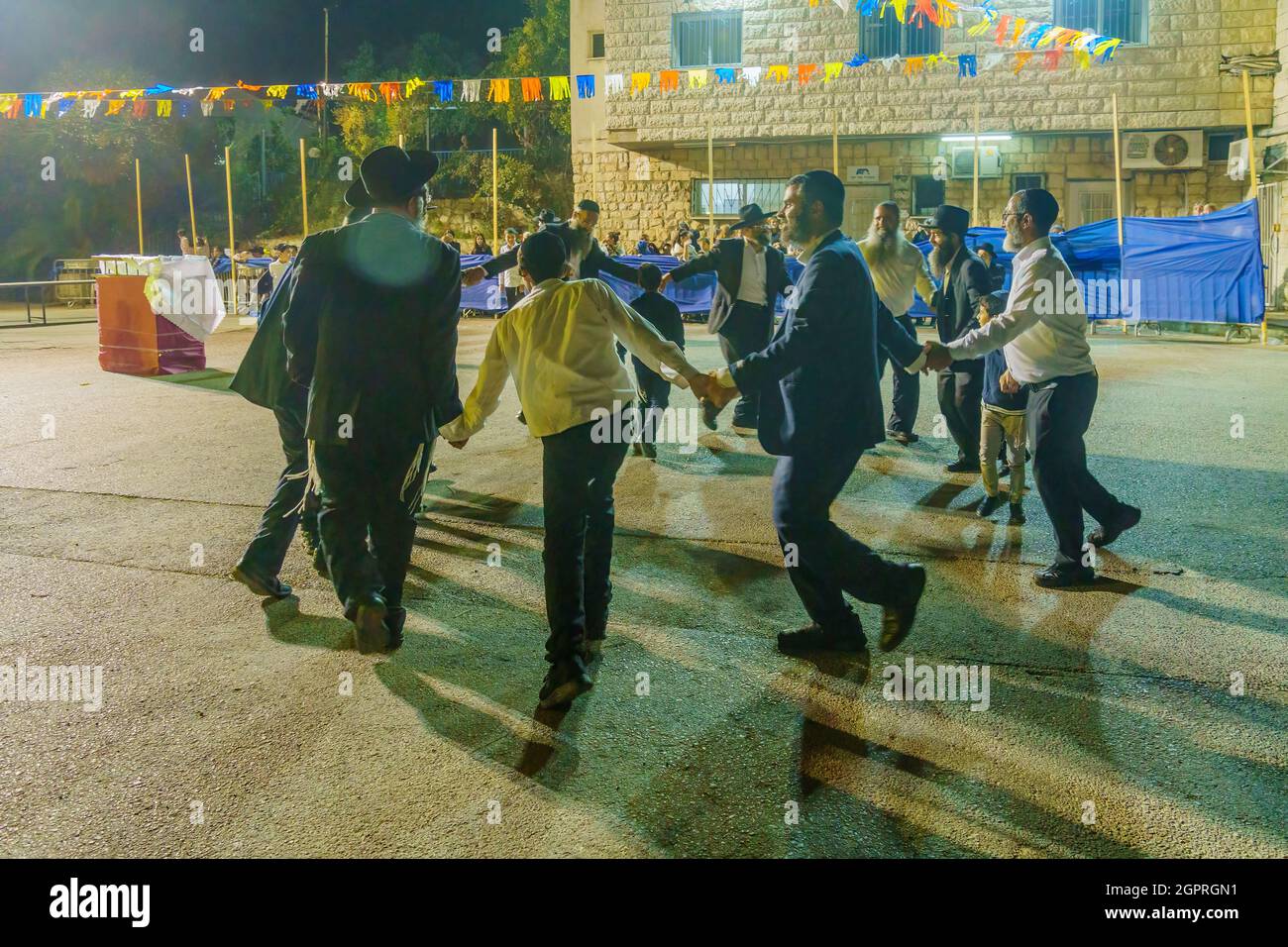 Safed, Israël - 28 septembre 2021 : les hommes juifs dansent, faisant partie de la tradition Simchat Torah, les femmes sont derrière la barrière, à Safed (Tzfat), en Israël Banque D'Images