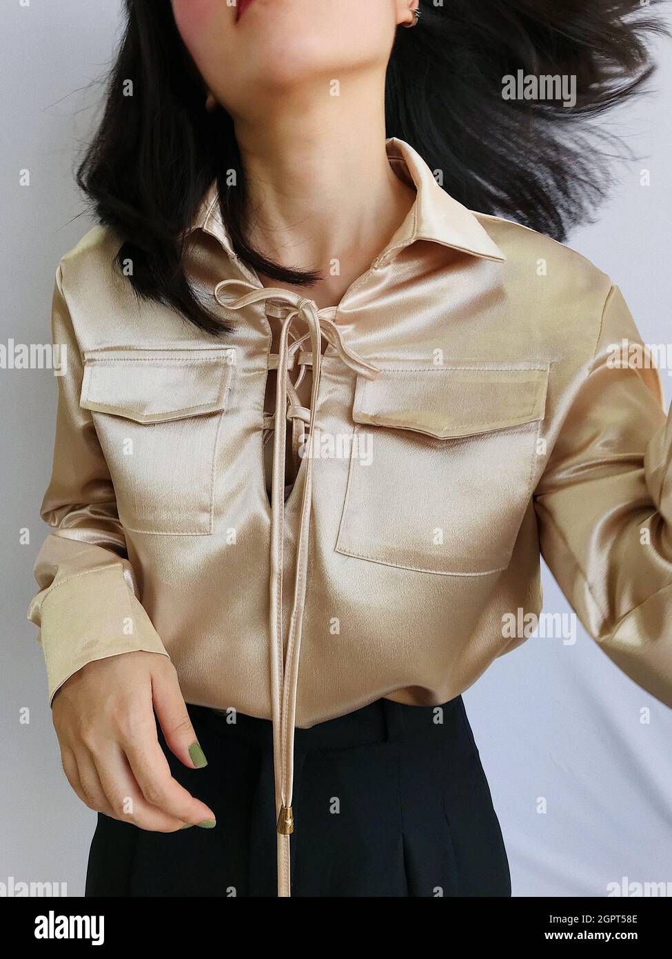 Photo de mode d'une femme portant une chemise dorée isolée sur fond blanc  Photo Stock - Alamy