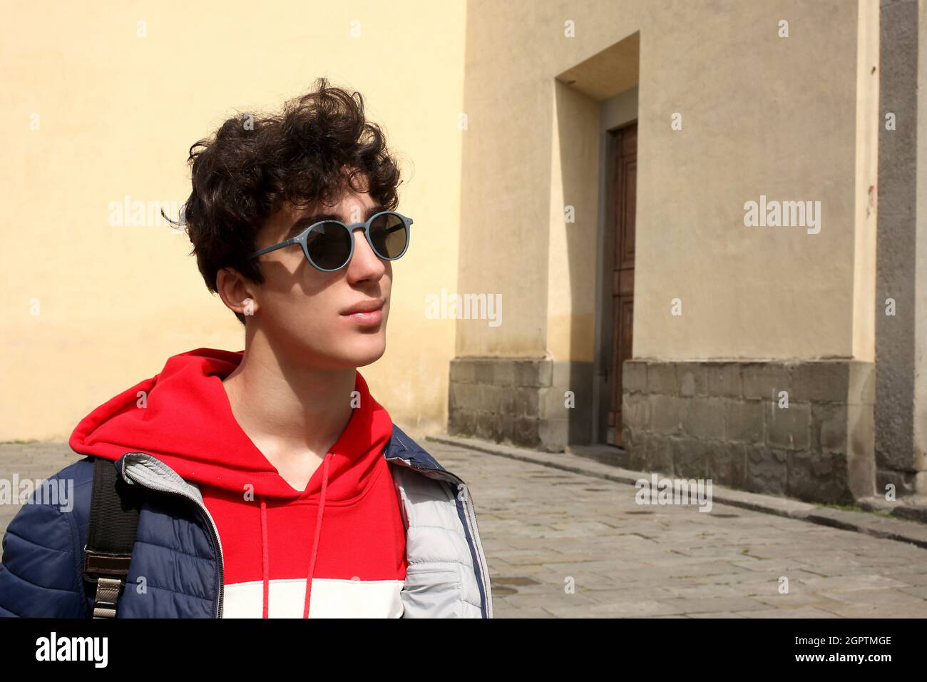 Portrait d'un garçon adolescent portant des lunettes de soleil debout  contre le mur Photo Stock - Alamy