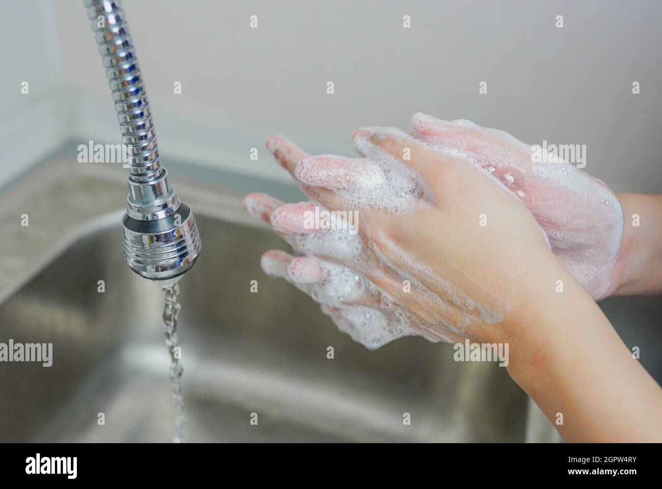Femme se lavant les mains avec du savon à l'évier.Dans la situation Covid-19 coronavirus. Banque D'Images