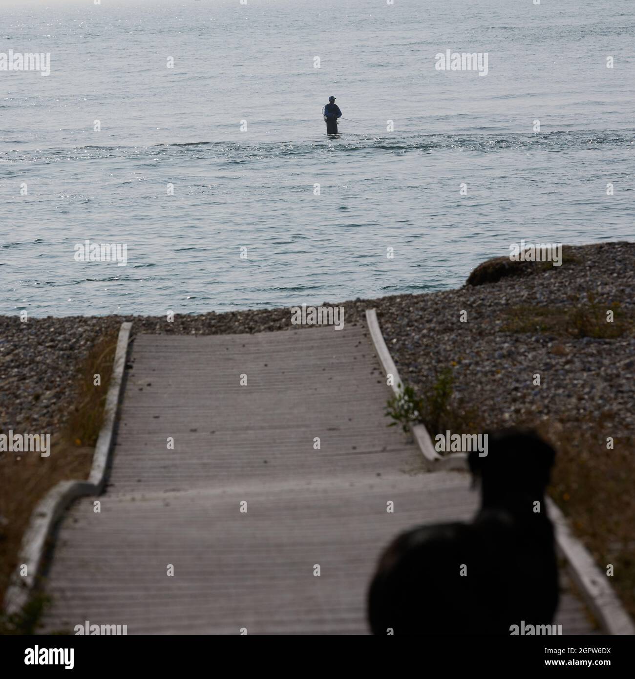 Pêcheur à la ligne vu la pêche de plage genou profondément dans l'eau. Banque D'Images