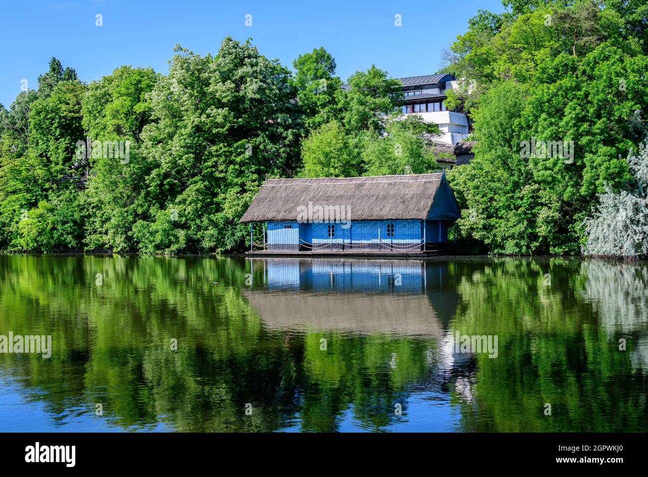 Paysage avec ancienne maison en bois sur le lac Herastrau et grands arbres verts dans le parc du Roi Michael I (ancien Herastrau) à Bucarest, Roumanie, dans un beau au Banque D'Images