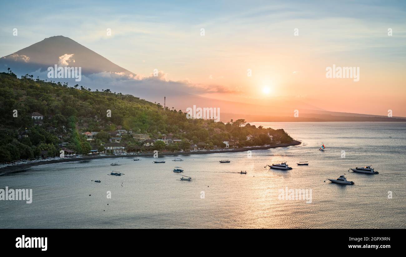 Paysage de l'île de Bali côte nord au coucher du soleil, avec le sommet du volcan du Mont Agung et les pentes de la forêt, et la mer de Java, depuis le sommet de la colline près d'Amed, Bali, Indo Banque D'Images