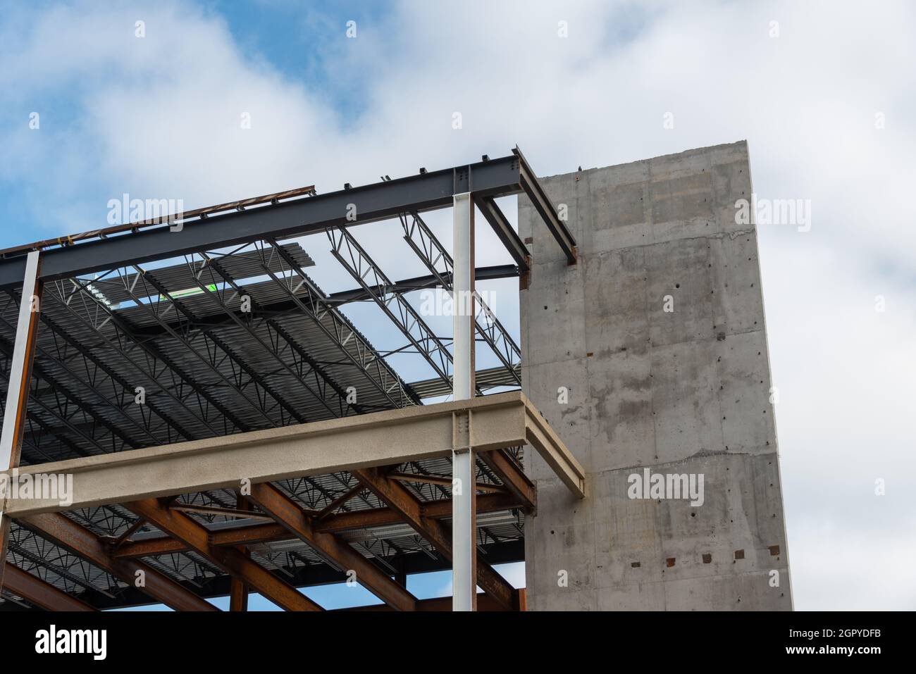 Un grand mur de bâtiment en métal de plusieurs étages avec des poutres en acier contre un ciel bleu.La structure industrielle est le coin d'un gratte-ciel Banque D'Images