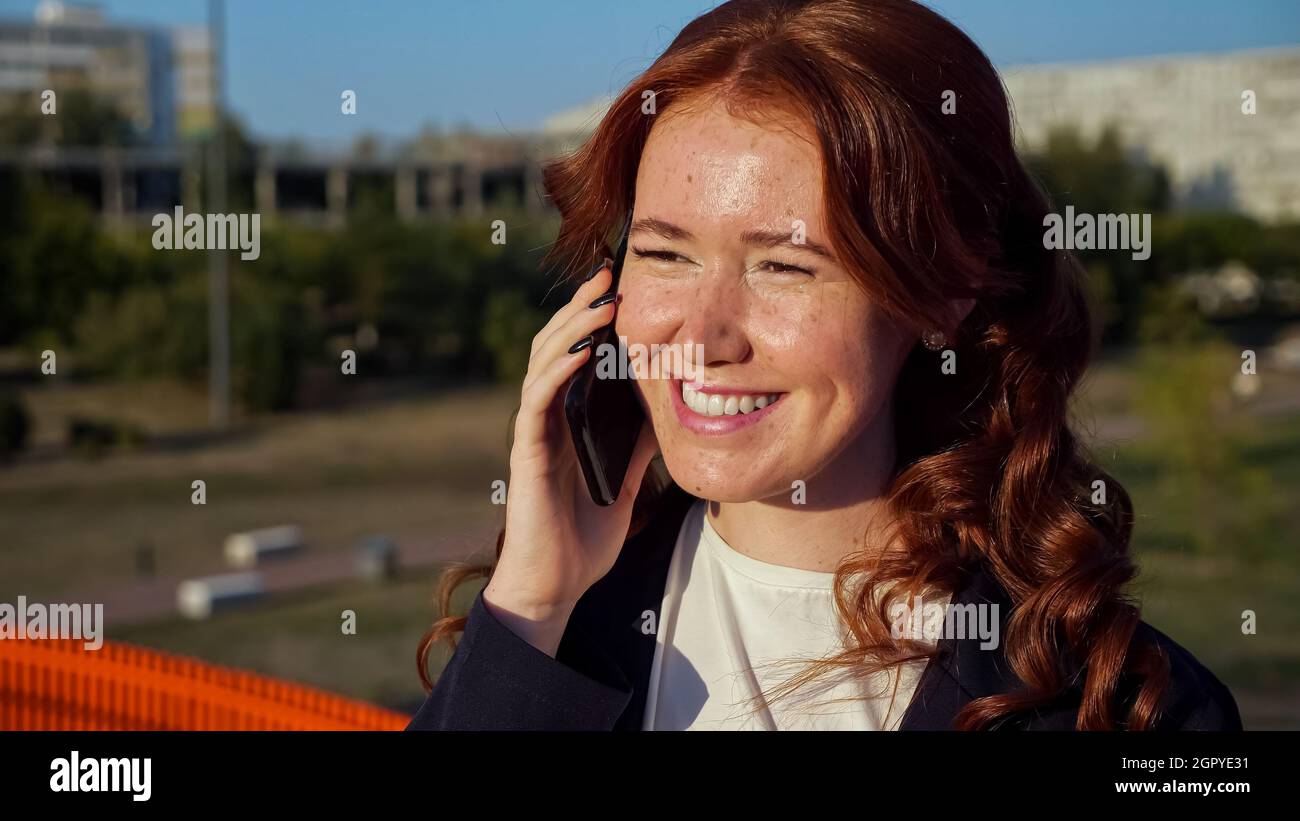 Une jeune femme qui a des taches sur le visage parle au téléphone au-dessus de la rue Banque D'Images