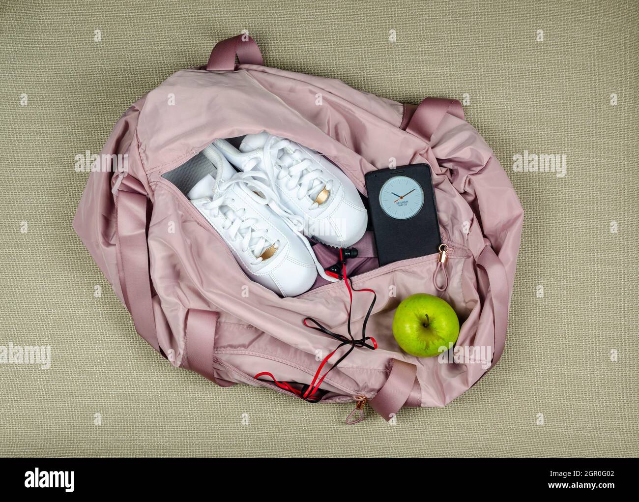 Sac de sport rose pour femme avec baskets blanches, pomme verte et  smartphone indiquant l'heure et la date Photo Stock - Alamy
