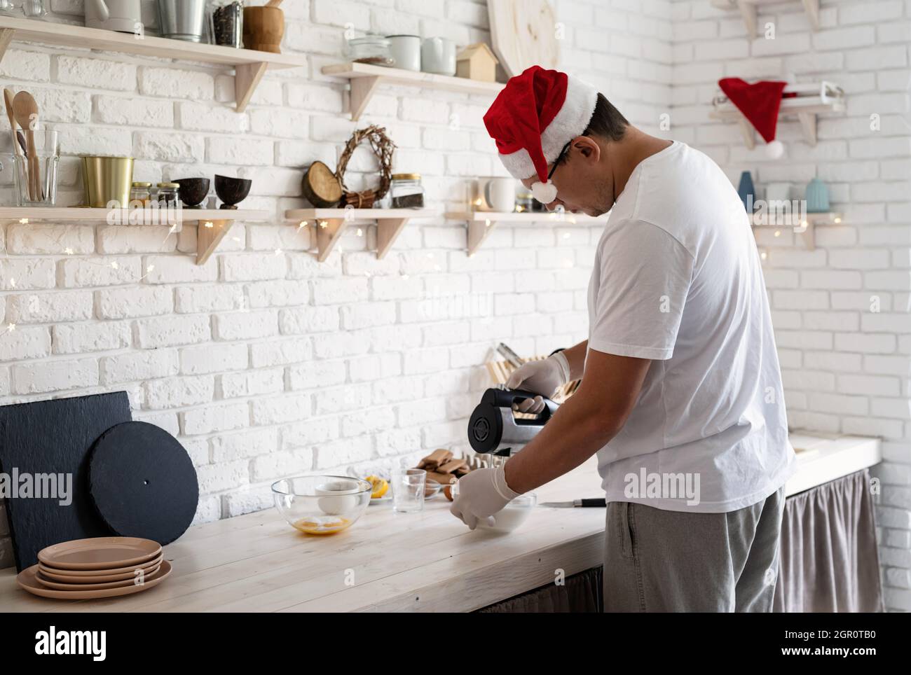Concept de pâtisserie de Noël.Homme au chapeau de père Noël faisant de la  meringue sur une table en bois blanc avec espace de copie Photo Stock -  Alamy